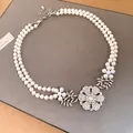 Elegant double-strand pearl necklace featuring a sparkling rhinestone flower pendant - Silver-White