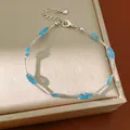 Zilverkleurige armband met blauwe mesh kralen en een elegante roze zirkoon bedel - Zilver-Blauw