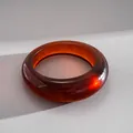 Primo piano di un bracciale in resina ambra con motivo marmorizzato su fondo ruvido. - Bangle / Marrone