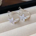 Detailed close-up showing the translucent resin flower design on silver hoop earrings - Silver Needle / Silver-White