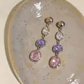 Detailed view of multi-colored teardrop and oval crystal earrings on a ceramic dish - Geometric Teardrop Long Tassel Style / Silver with White Purple Pink