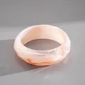 Close-up macro view of a marbled peach acrylic bangle with geometric faceted edges - Irregular Faceted Bangle