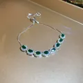 Detalle macro de una pulsera de lujo ajustable con siete circonitas verdes de forma oval. - Estilo 32# Verde Ovalado