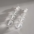 Gros plan de boucles d'oreilles pendantes en perles de cristal rondes - Style de Gland à Perles Rondes à 3 Niveaux / Transparent