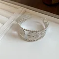 Close-up view of a silver open cuff bracelet with vintage floral and leaf patterns - Hollow Floral Leaf Style (8#)