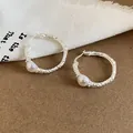 Dettaglio di orecchini a cerchio vintage in argento stropicciato con perle - Argento
