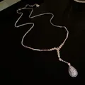 Elegante silberfarbene Halskette mit Zirkonia-Tropfenanhänger auf schwarzer Fläche - Umweltfreundliches Silber