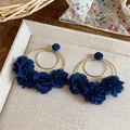 Dettaglio di eleganti orecchini a cerchio dorati con fiori in chiffon blu navy per vacanza - Stile Perno in Argento / Blu