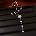 Detail of a vintage pearl beaded necklace with a crystal flower on a black tray. - Flower Pendant Necklace / Silver-White