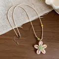 Vista dettagliata del ciondolo a fiore di conchiglia con centro di perline verdi su collana - Collana di Fiori / Bianco e Verde