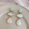 Elegant three-tier resin dangling earrings with pearlescent finish and gold-tone trim detail - White Contrast / Blue