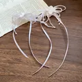 Close-up of elegant white pearl beaded choker with flower details and flowing ribbons - White (Silver Pin)
