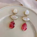 Detailed view of elegant marbled resin drop earrings featuring red and white waterdrop pendants - White Contrast / Rose Red
