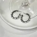 Detailed view of gunmetal hoop earrings with clear zircons and white cat's eye stones. - C-Shaped Design (HE33314) / Gun Black and White