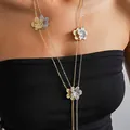 Detail showing a vintage-style gold and silver metal floral tassel necklace worn by a model - Flower Tassel Necklace