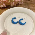 Vista detallada de pendientes de esmalte azul en forma de C con motivo de lunares rojos - Azul