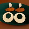 Macro detail view of geometric wood and resin drop earrings displayed on green velvet - Silver Post Geometric Round Style / White-Coffee