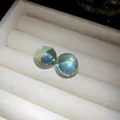 Detailed macro view of round translucent light blue resin stud earrings with silver needles - Silver Earring Post Style / Green