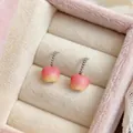 Gros plan de jolies boucles d'oreilles pommes en résine rose avec chaînes argentées. - En Forme de Pomme / Rose