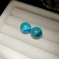 Detailed view of translucent turquoise resin sphere earrings displayed in a white jewelry box. - Silver Earring Post Style / Blue