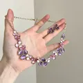 Close-up of elegant purple and pink enamel flower necklace and earrings jewelry set - Earrings Necklace Set / Gold And Purple
