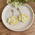 Close-up of yellow floral drop earrings with pearl and crystal bead details - Yellow