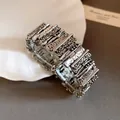 Macro view of retro metal irregular patchwork bracelet with hammered texture details. - Silver