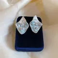 Primo piano di orecchini a rombo in argento con texture stropicciata e zirconi brillanti. - Stile Rombo Increspato / Blu