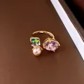 Detailed view of an elegant gold open ring with purple stone, crystal, and pearl decoration - Open Ring / Gold-Pink