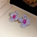 Nahaufnahme eleganter Blumenohrringe mit rosa und weißen Pavé-Zirkoniasteinen. - Ohrstecker (1) / Umweltfreundlicher Silberstift / Silber-Rosa