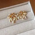 Close-up view of elegant 18k gold plated fireworks stud earrings featuring white enamel and zircons - Firework Design Style (HE31775) / Gold with White