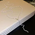 Detailed close-up of elegant pearl and crystal bead necklace on cream textured display box - Single Layer / Silver White