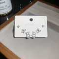 Primo piano di un set di orecchini a lobo in zircone scintillante con fiocchi e orsi - Set da 6 Pezzi / Argento