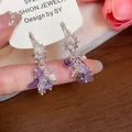 Detailed close-up of silver conch stud earrings with purple gemstones and pearls - Silver (Silver Pin) / Purple