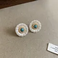 Detailed macro view of retro silver daisy stud earrings with turquoise center stone - Daisy Petal Style