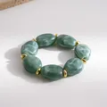 Close-up detail view of green marble texture beads on a stylish elastic bracelet. - Green