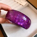 Close-up detail of a vibrant purple resin bangle with star and snowflake glitter patterns - Purple