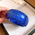 Macro view of high-quality blue resin bangle with sparkling star-shaped glitter inclusions - Blue