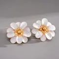 Close-up of white enamel flower stud earrings with elegant gold center and petals. - Steel Needle Style / White