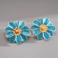 Detailed view of blue enamel flower earrings with gold-tone centers on grey surface - Steel Needle Style / Blue