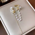 Dettaglio di un elegante clip per orecchio a farfalla placcata oro 18K con perle e zirconi - Ear Cuff (Singolo) / Oro