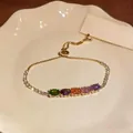 Detail of gold adjustable bracelet featuring multi-colored oval cubic zirconia stones - Colorful Zirconia Bracelet - Horizontal / Gold