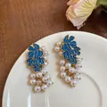 Detailed view of elegant blue enamel grape earrings featuring delicate white pearl clusters - Gold Blue White