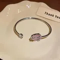 Detail of silver tulip bangle with pink cat's eye stone and sparkling zircons - Silver