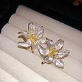 Close-up of vintage enamel flower stud earrings with gold accents in a jewelry box - Gold-White