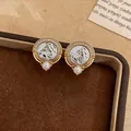 Close-up view of vintage round stud earrings featuring zircon-encrusted horse head and pearls - Horse Head Relief Round Style / Gold and Silver