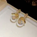 Dettaglio macro degli orecchini di perle placcati oro 18K con zirconi brillanti. - Stile Ciondolo Perla Tonda / Oro