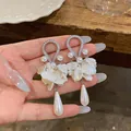 Dettaglio degli orecchini retrò in zircone con perle e petali a forma di goccia - Bianco