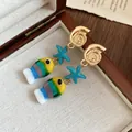 Vista dettagliata di orecchini a tema marino con conchiglie dorate e ciondoli a pesce - Blu Multicolore