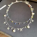 Vue détaillée du collier double épaisseur argenté avec breloques coquillage, étoile de mer - Argent-Multicolore